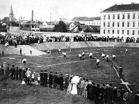 Prva javna nogometna utakmica u Hrvatskoj, Marulićev trg 1906. godine. U pozadini Plinara sa dimnjakom- iza nje toranj Evangelističke crkve
